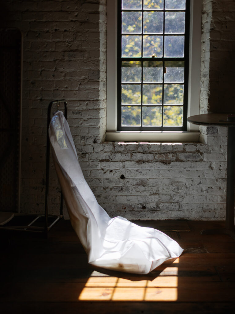 Roswell Mill wedding dress hanging in window.