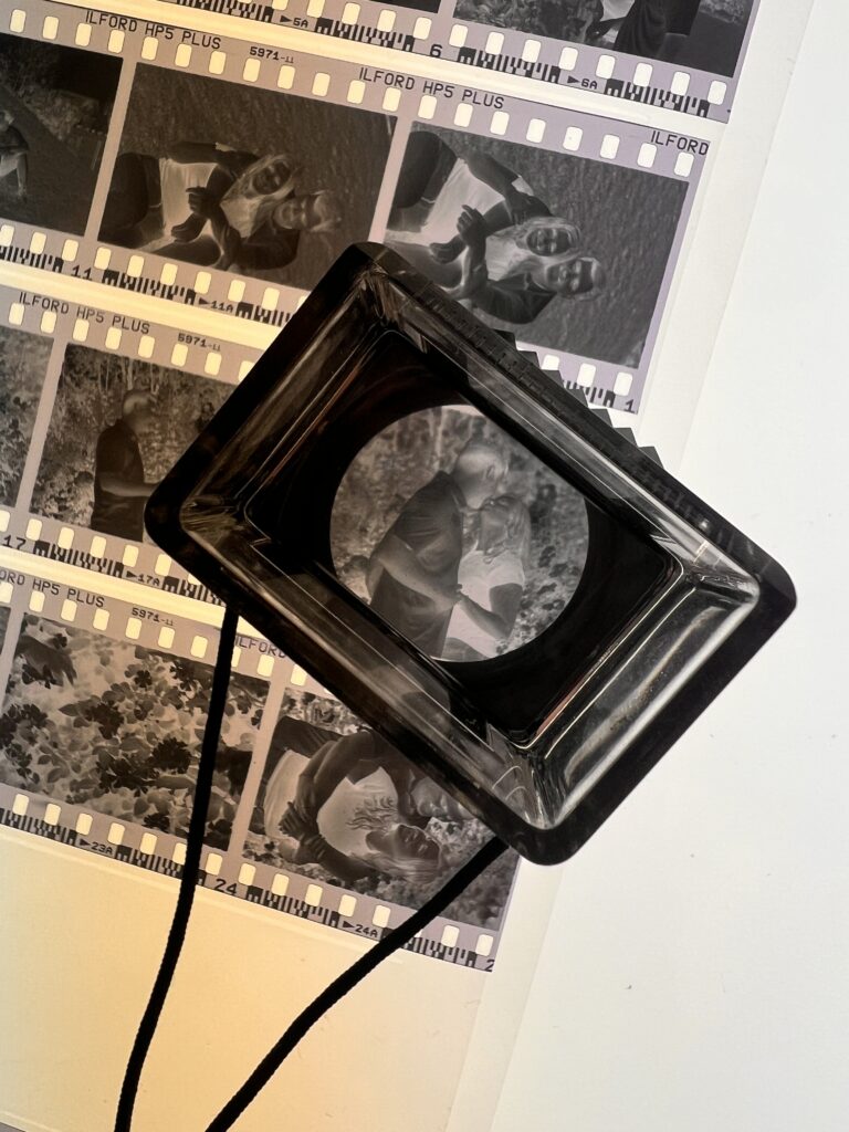 Magnifier showing strips of film from a dark room couple's session
